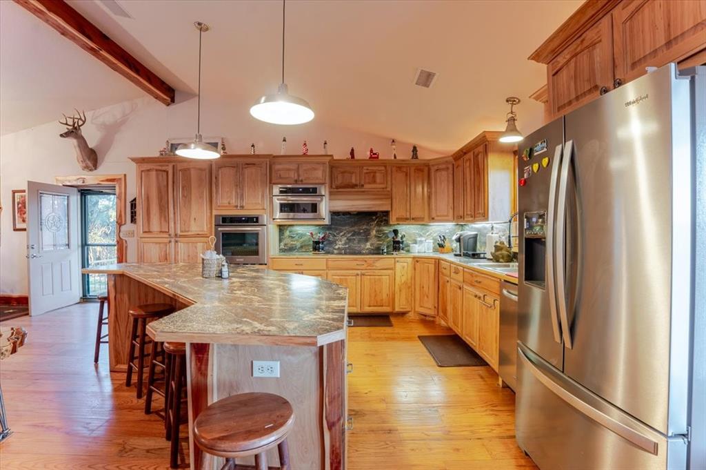 2117 Highway 6 Cisco, TX 76437 - Photo 12 of 35 a kitchen with granite countertop a table chairs stainless steel appliances and cabinets