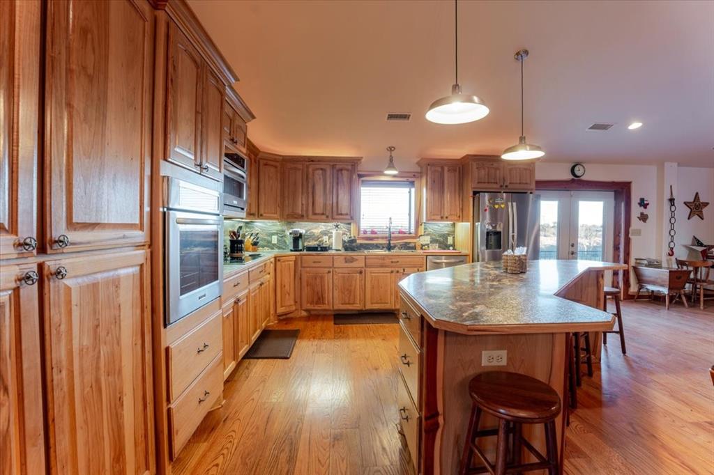 2117 Highway 6 Cisco, TX 76437 - Photo 13 of 35 a kitchen with stainless steel appliances granite countertop counter space a sink and a refrigerator