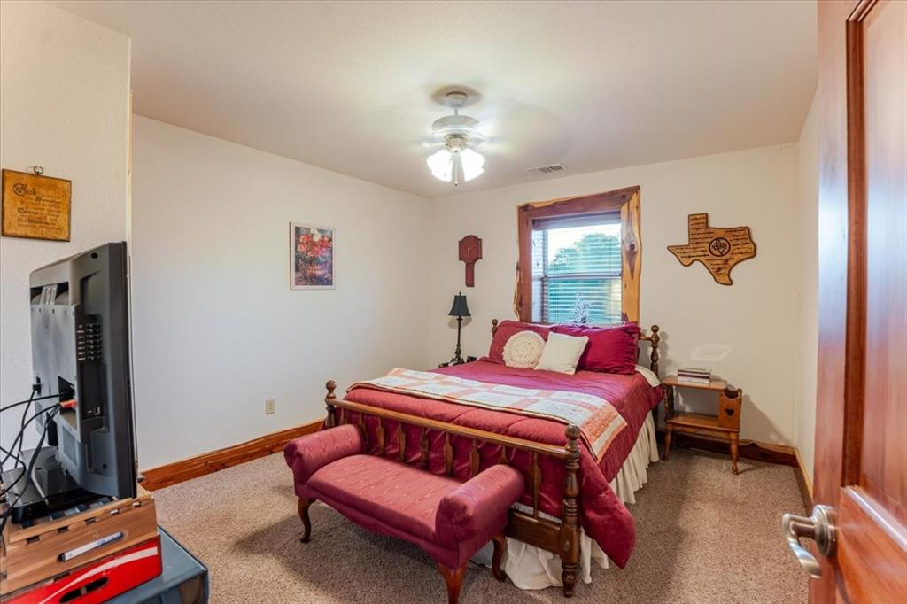 2117 Highway 6 Cisco, TX 76437 - Photo 14 of 35 a bedroom with a bed and a chandelier