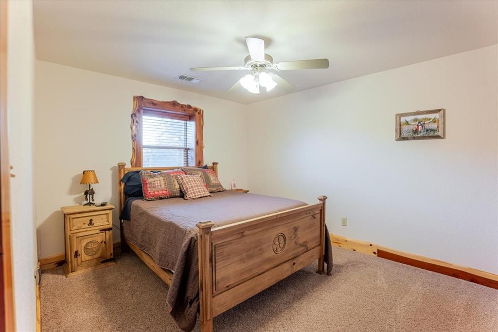 2117 Highway 6 Cisco, TX 76437 - Photo 18 of 35 a bedroom with a bed and a chandelier