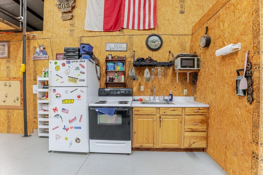 2117 Highway 6 Cisco, TX 76437 - Photo 22 of 35 a utility room with stainless steel appliances a stove and a refrigerator
