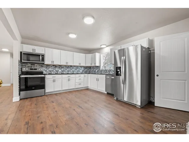 a kitchen with stainless steel appliances granite countertop a refrigerator a stove a sink and a microwave