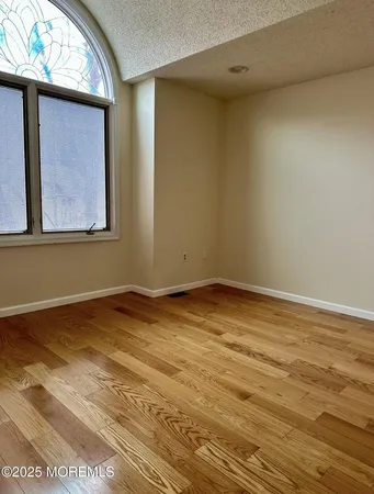 a view of a room with wooden floor and small window