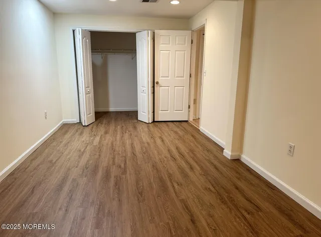an empty room with wooden floor and closet