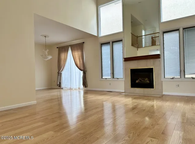 a view of empty room with wooden floor and fireplace