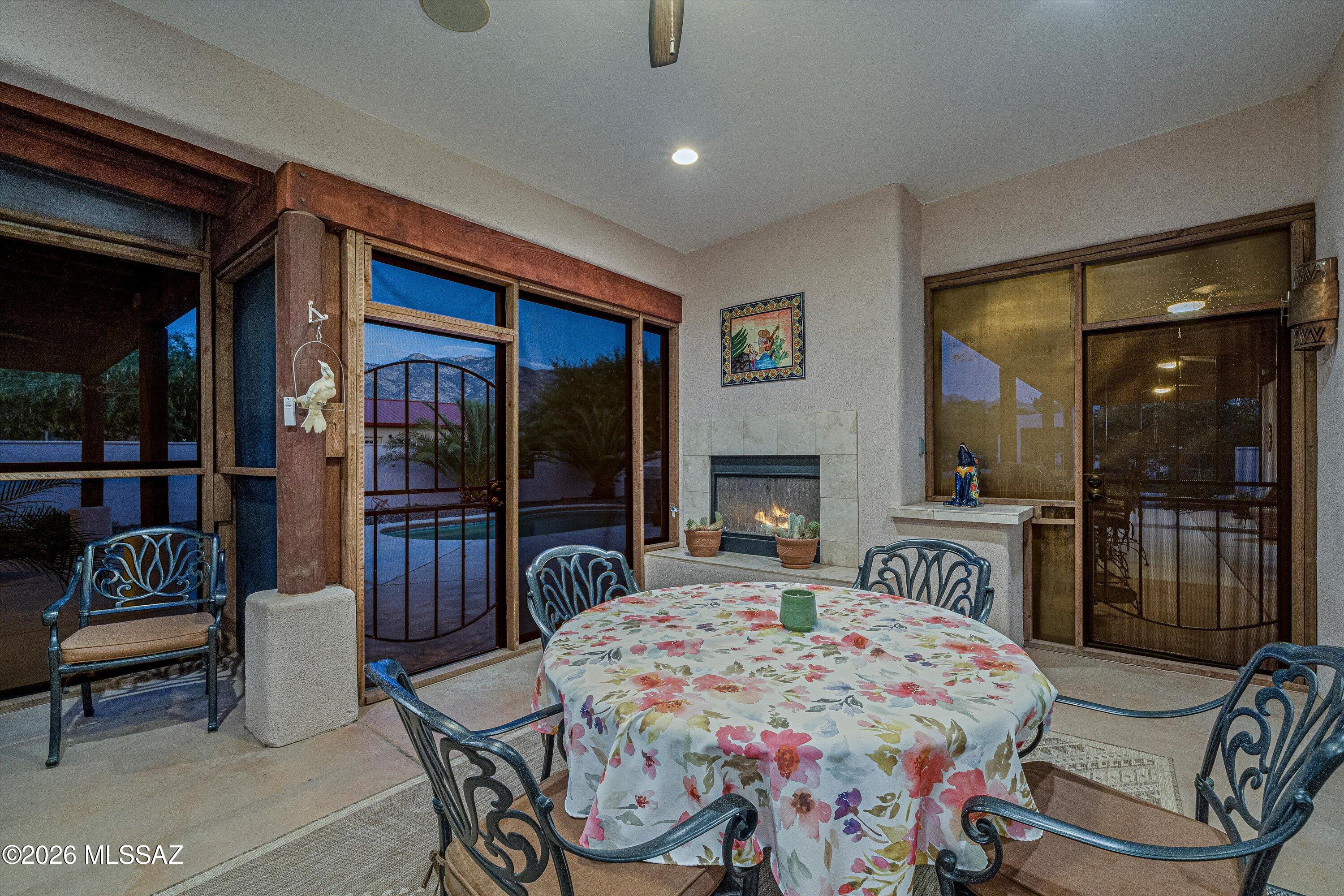 4677 East Rail N Road Tucson, AZ 85739 - Photo 16 of 48 Screened patio with fireplace between the great room, kitchen and dining room. Patio door to the backyard oasis.