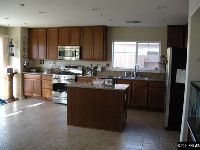 8931 Grisom Way Reno, NV 89506 - Photo 4 of 13 a kitchen with a sink stove top oven and refrigerator