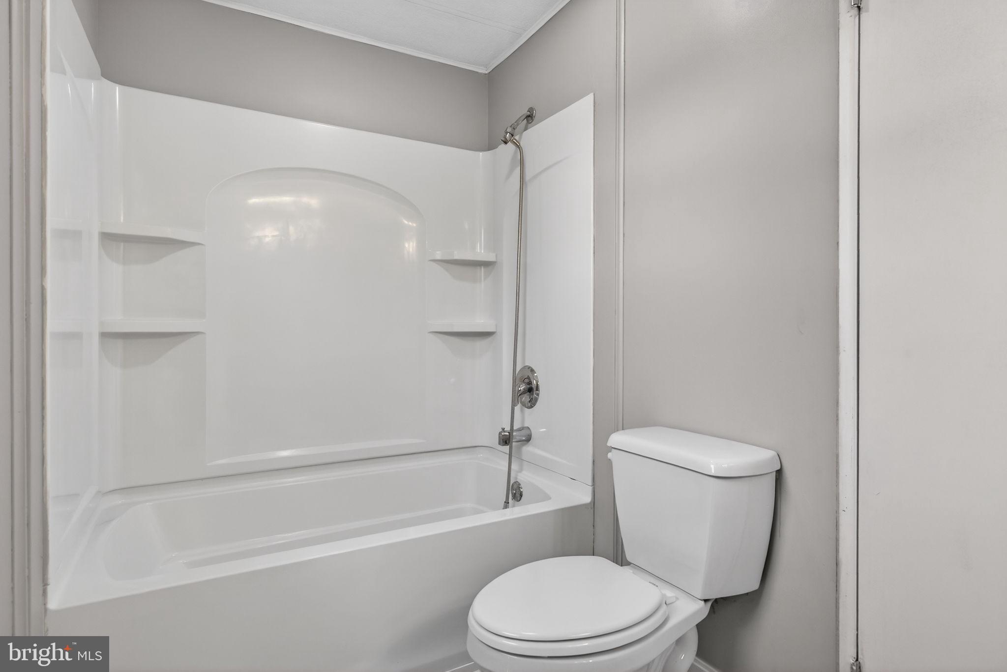 4918 Pleasant Valley Road York, PA 17406 - Photo 19 of 30 a white toilet and tub next to a white cabinet