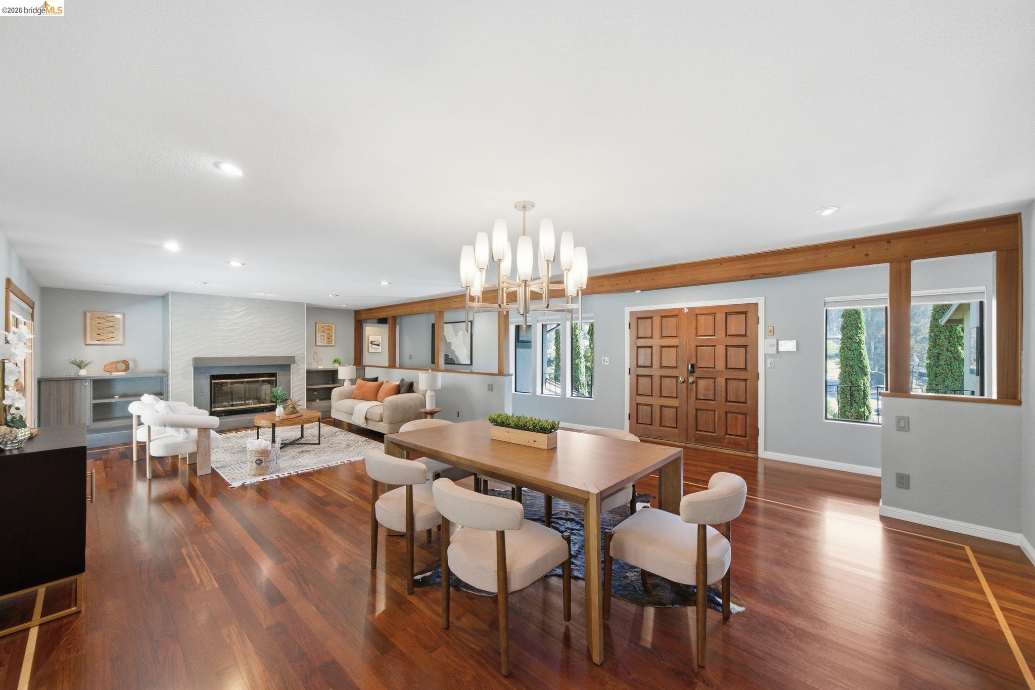 11133 Golf Links Road Oakland, CA 94605 - Photo 13 of 57 Expansive living area featuring rich wood-finish flooring, a contemporary fireplace with a stone mantel, recessed lighting, and exposed wood beams