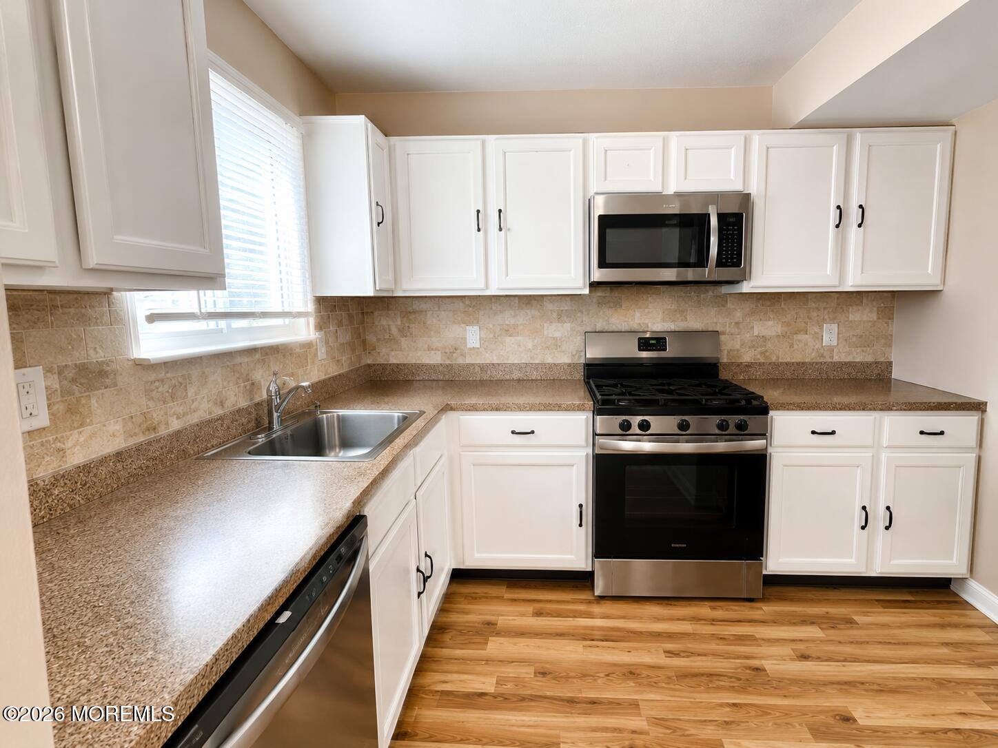 1 Max Place Howell, NJ 07731 - Photo 7 of 16 a kitchen with stainless steel appliances white cabinets and a stove top oven