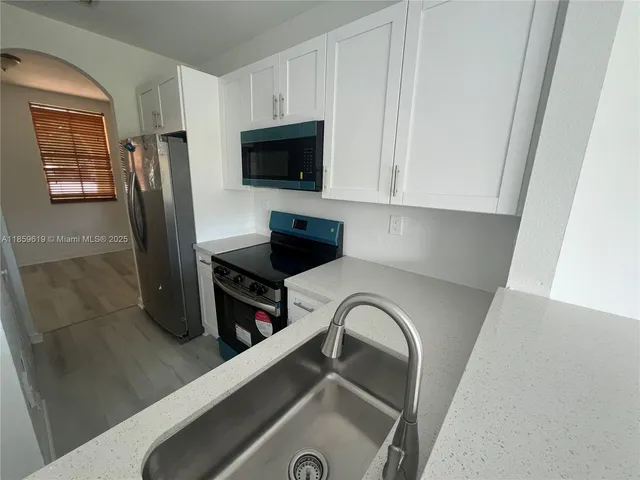 a kitchen with stainless steel appliances granite countertop a refrigerator and a stove top oven