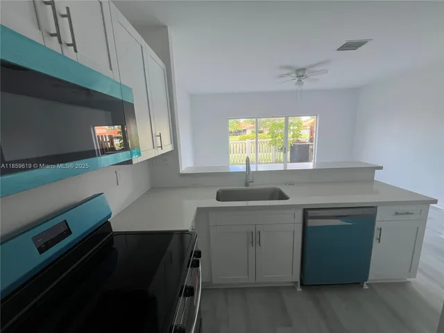 a kitchen with a sink cabinets and window