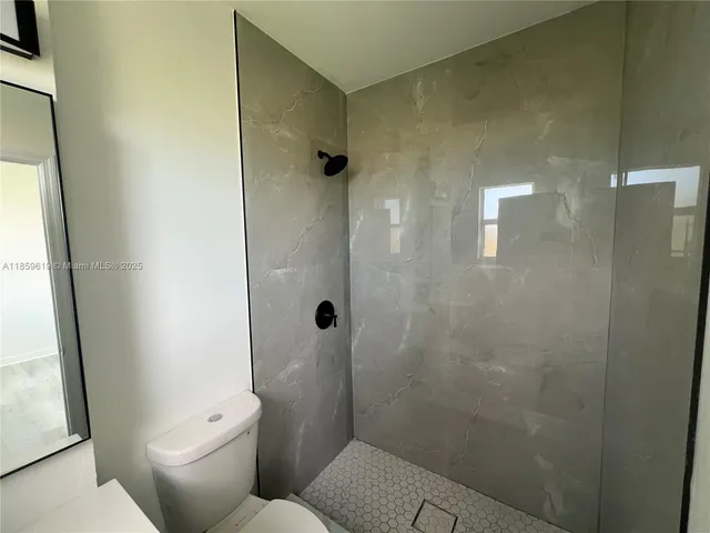 a bathroom with a toilet and a shower