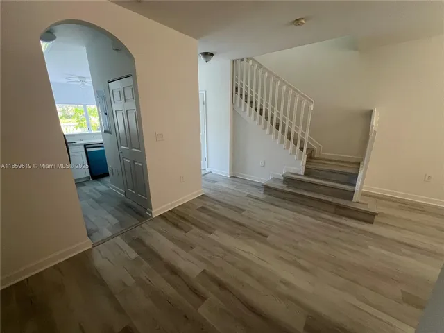 a view of a livingroom with wooden floor and stairs