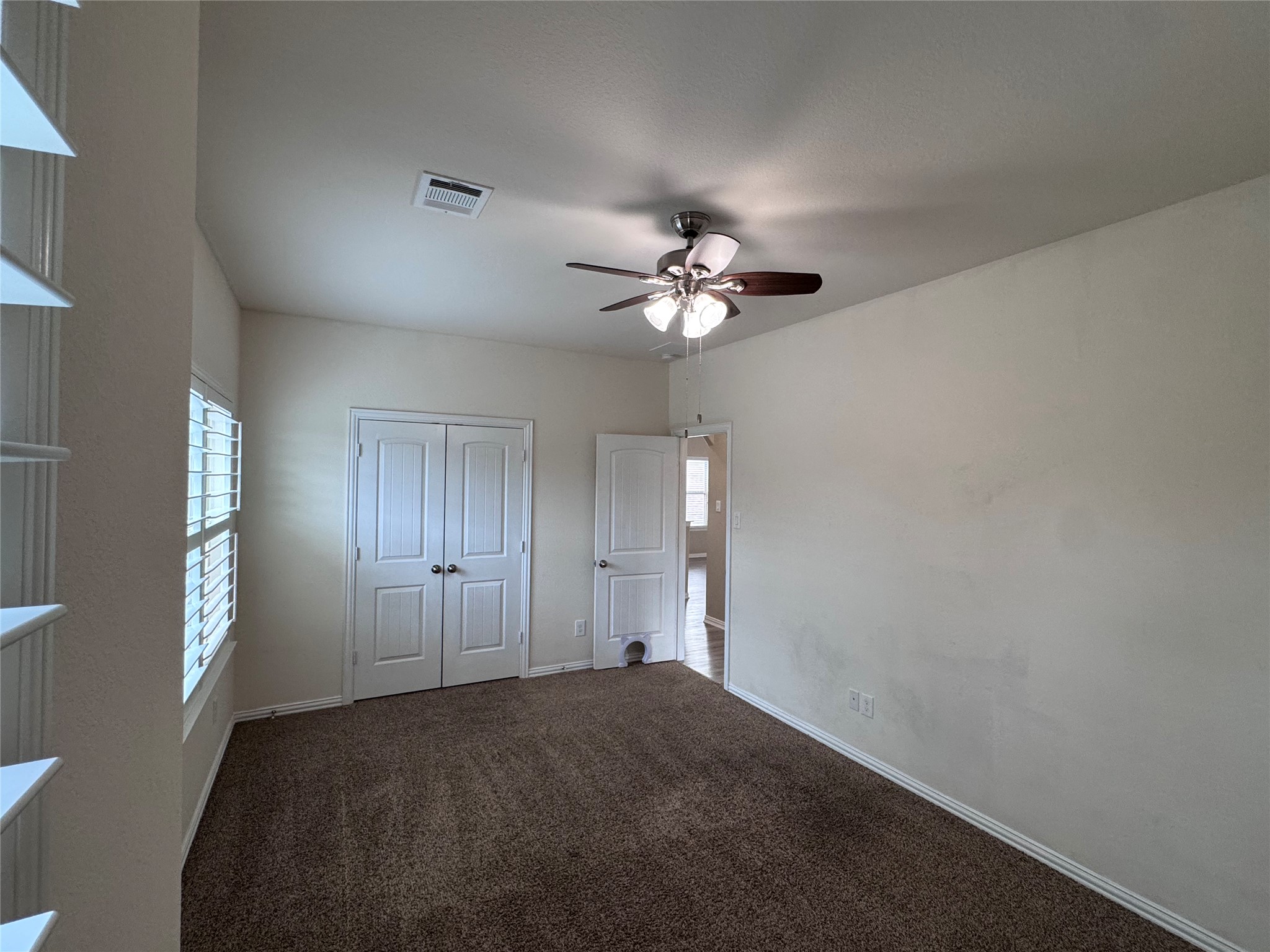 2605 Rough Berry Road Pflugerville, TX 78660 - Photo 23 of 40 A comfortable room features carpeted flooring, a practical ceiling fan, and ample natural illumination.