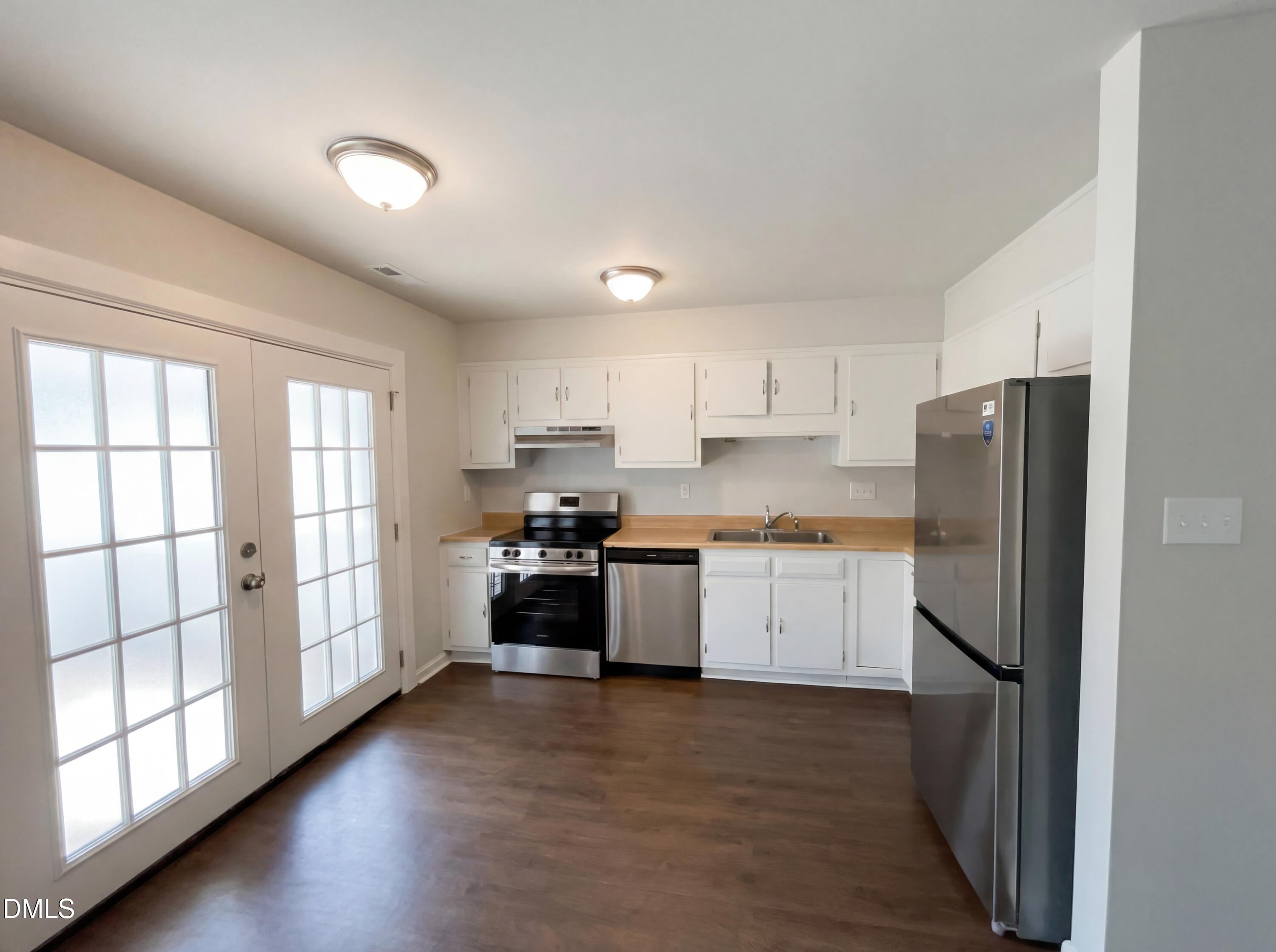 4113 Mill Bridge Road Hope Mills, NC 28348 - Photo 5 of 18 a kitchen with a refrigerator stove and wooden floor