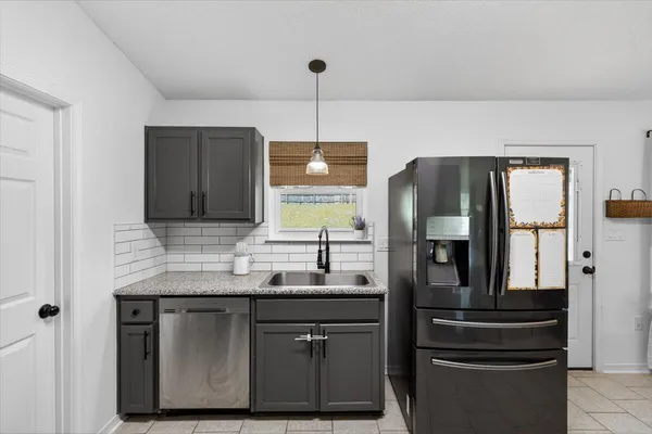 a kitchen with stainless steel appliances granite countertop a sink refrigerator and microwave