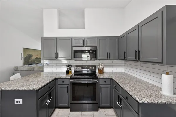 a kitchen with stainless steel appliances granite countertop a sink and a refrigerator