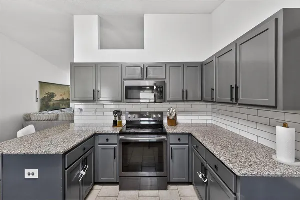 a kitchen with stainless steel appliances granite countertop a sink stove and cabinets