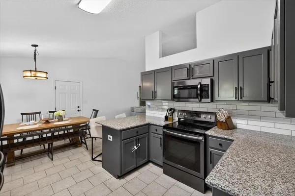 a kitchen with stainless steel appliances granite countertop a sink stove and cabinets