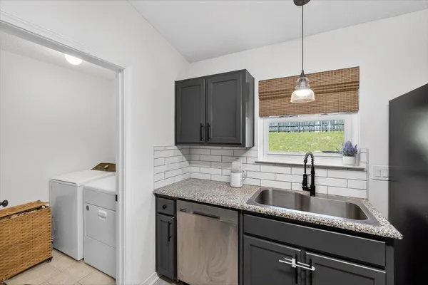 a kitchen with stainless steel appliances granite countertop a sink dishwasher stove top oven and refrigerator