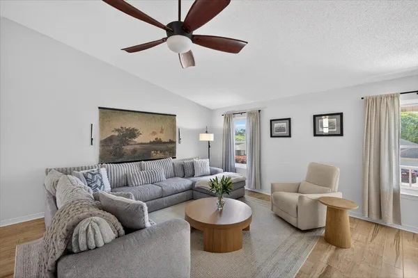 a living room with furniture and a wooden floor