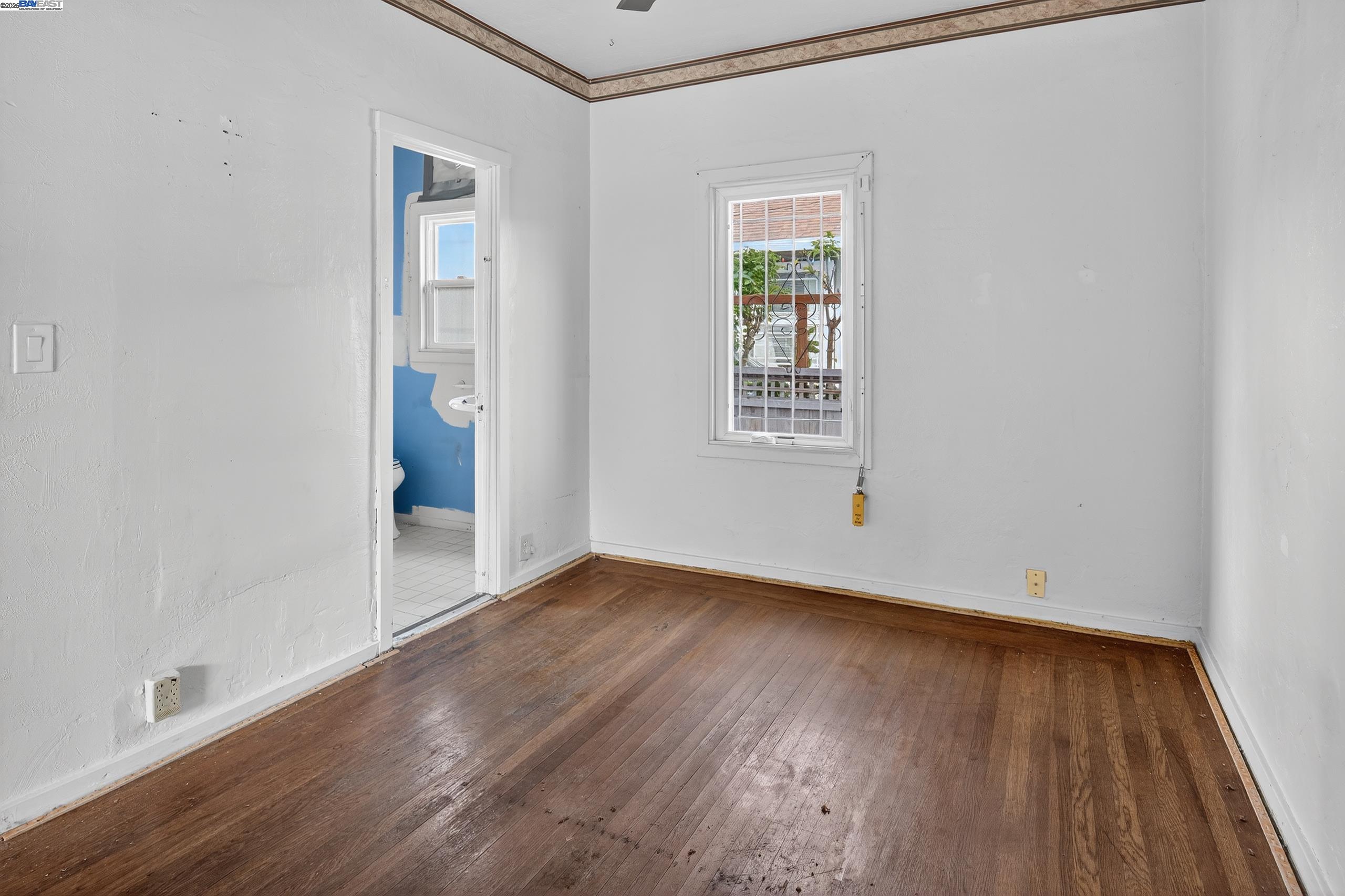 7412 Weld Street Oakland, CA 94621 - Photo 12 of 19 an empty room with wooden floor and windows