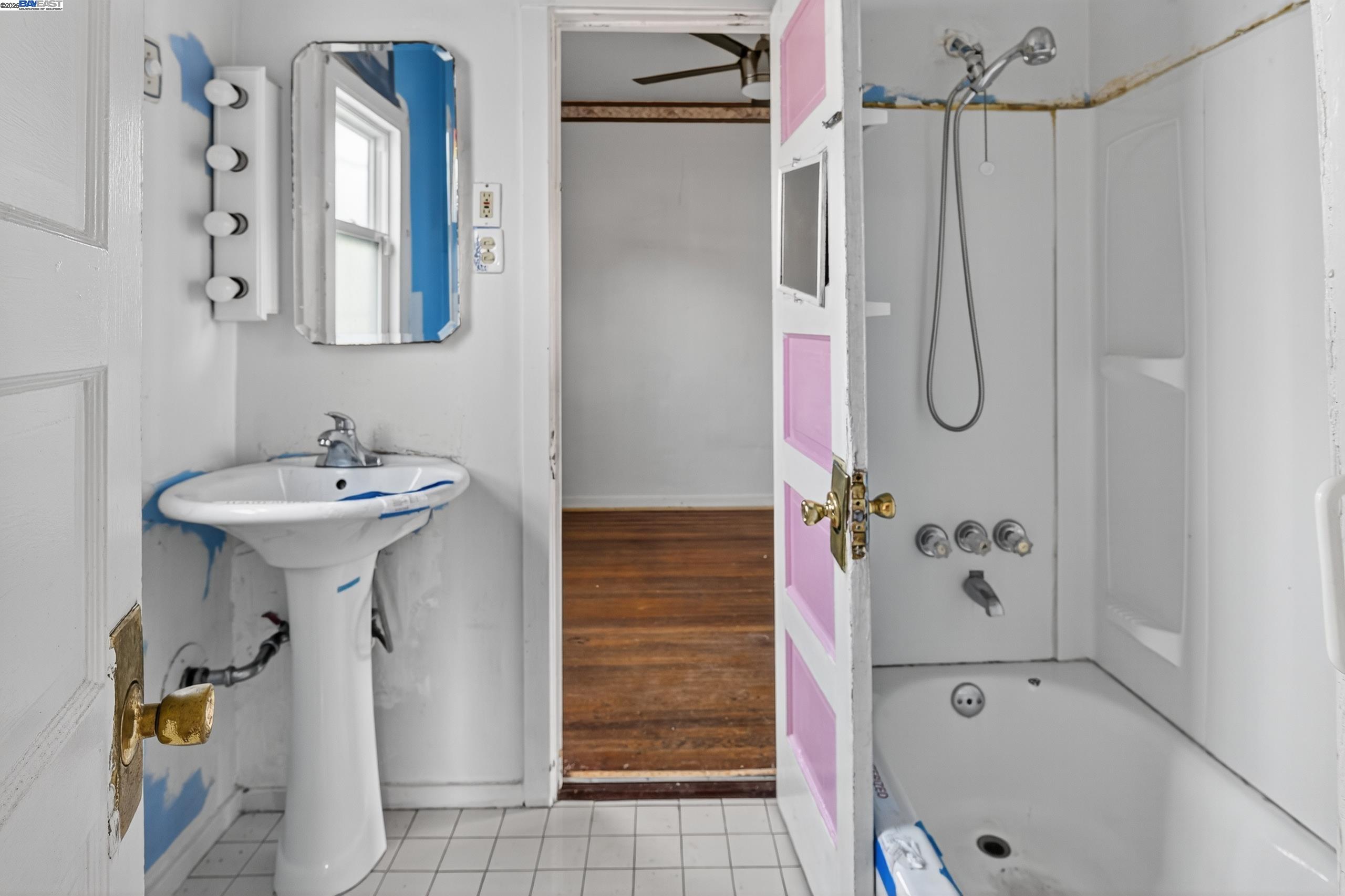 7412 Weld Street Oakland, CA 94621 - Photo 13 of 19 a bathroom with a sink a mirror and shower