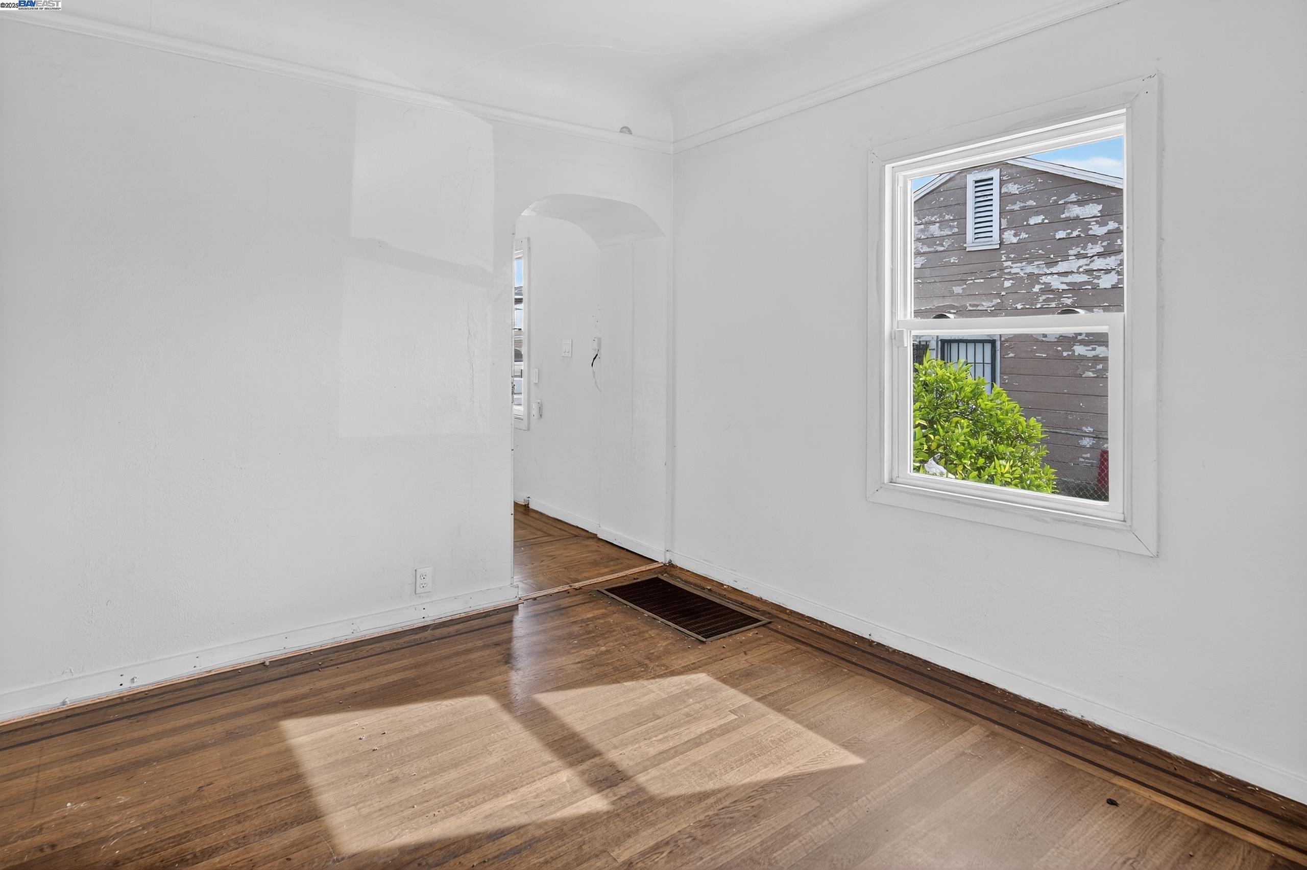 7412 Weld Street Oakland, CA 94621 - Photo 8 of 19 an empty room with wooden floor and windows