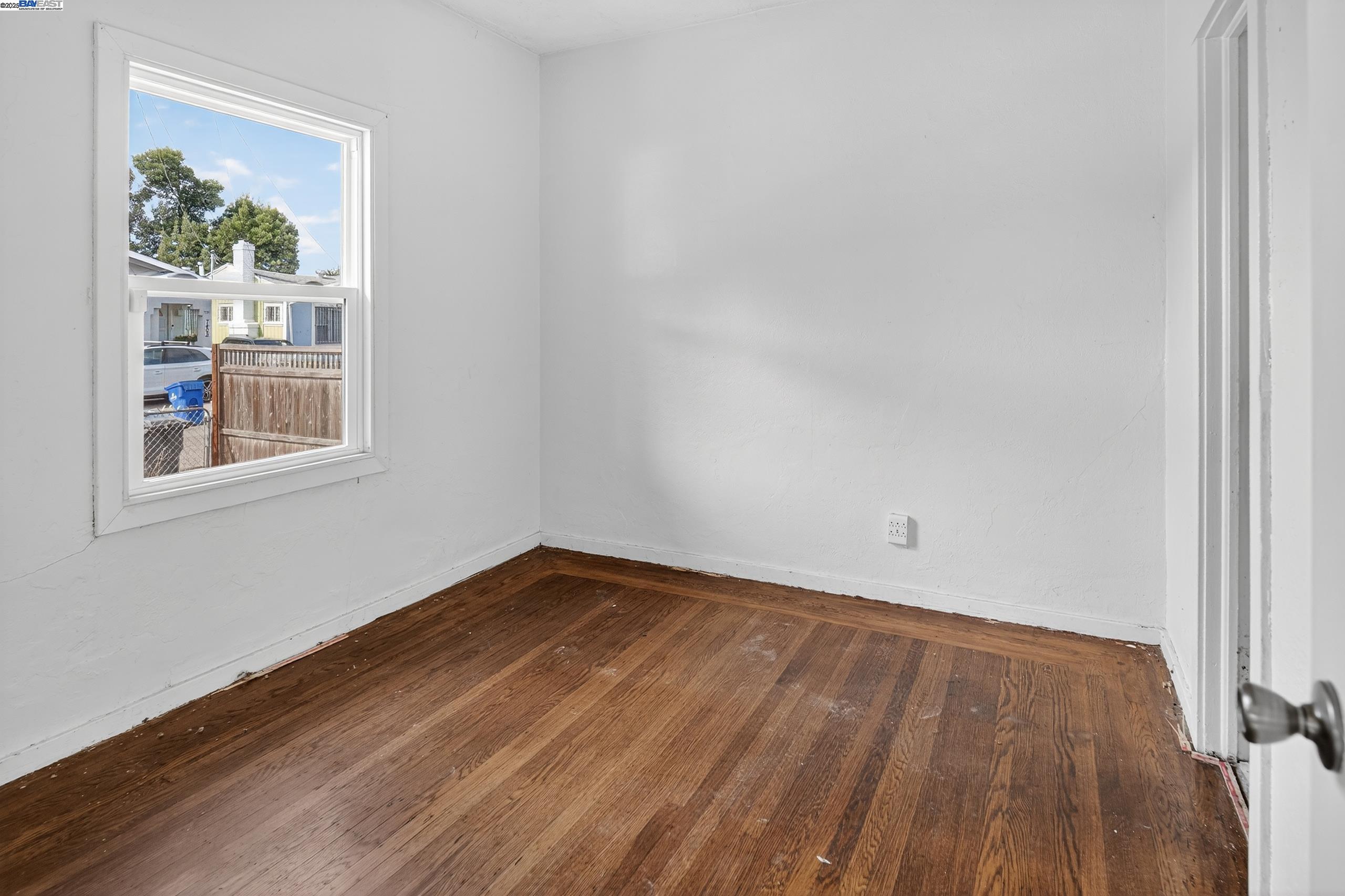 7412 Weld Street Oakland, CA 94621 - Photo 10 of 19 a view of an empty room with wooden floor and a window