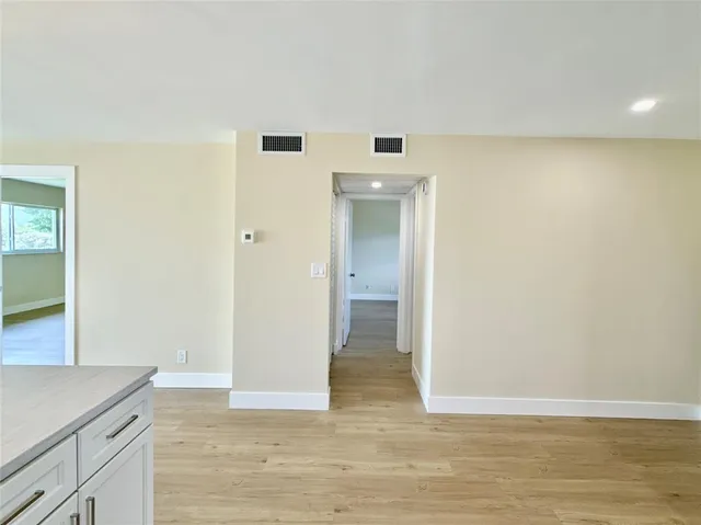 a view of a kitchen with wooden floor and a sink