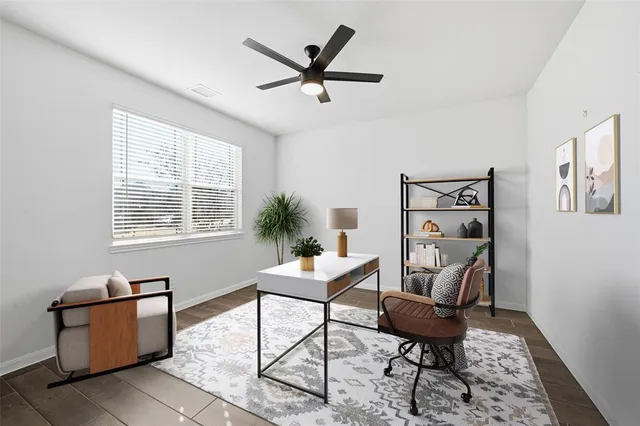 an empty room with wooden floor ceiling fan and windows