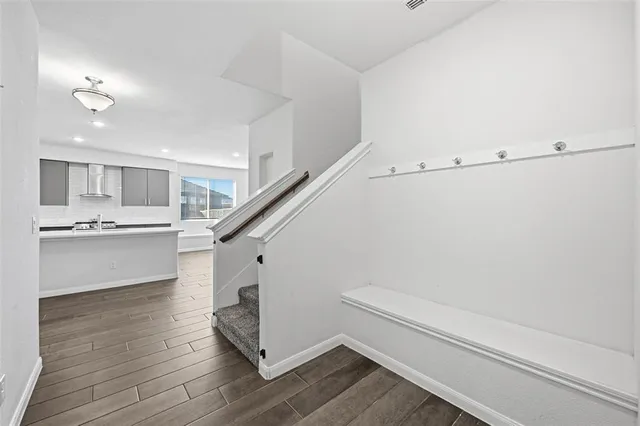 a view of a hallway with wooden floor and a living room
