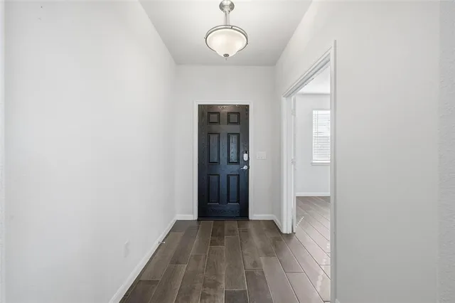 a large kitchen with a center island wooden floor stainless steel appliances and cabinets