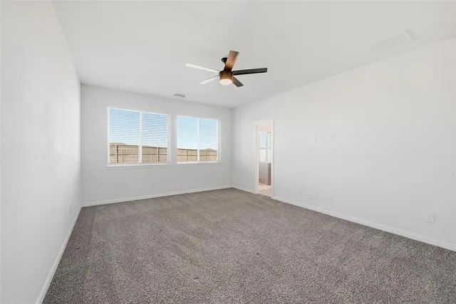 an empty room with windows and ceiling fan view