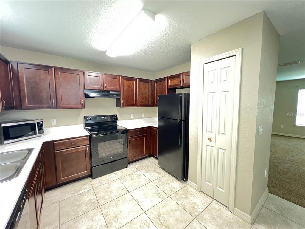 2427 Southwest 168th Loop Ocala, FL 34473 - Photo 11 of 21 a kitchen with a refrigerator sink and wooden cabinets