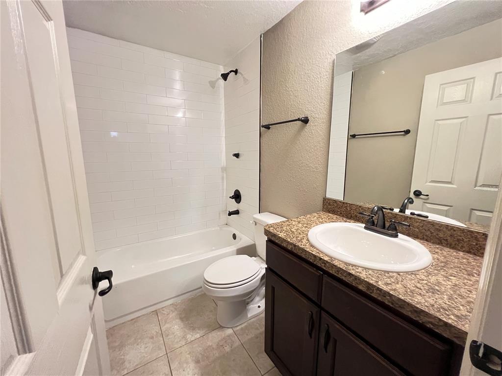 2427 Southwest 168th Loop Ocala, FL 34473 - Photo 14 of 21 a bathroom with a granite countertop sink toilet mirror and bathtub