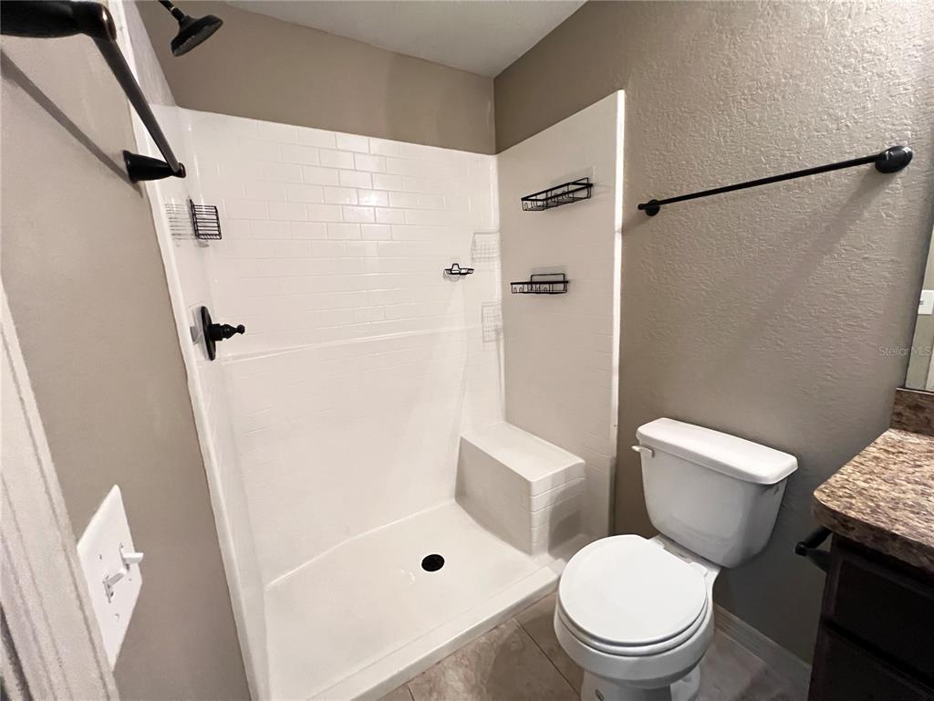2427 Southwest 168th Loop Ocala, FL 34473 - Photo 20 of 21 a white toilet sitting next to a bathroom sink and a shower