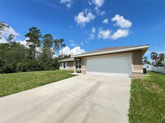 a view of a house with a yard and a garage