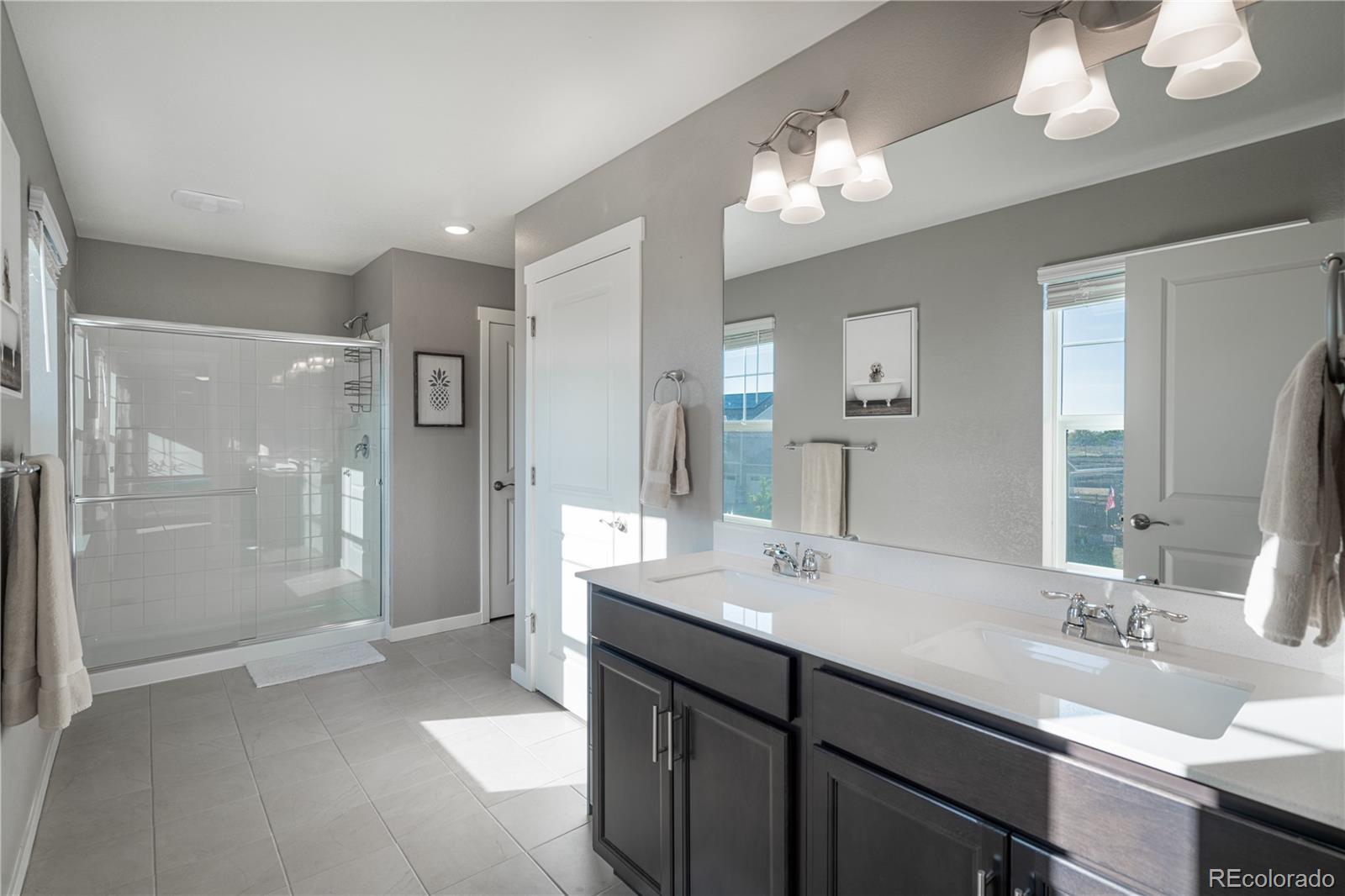 1521 Sun River Road Berthoud, CO 80513 - Photo 14 of 23 a bathroom with a sink a shower a mirror and a shower