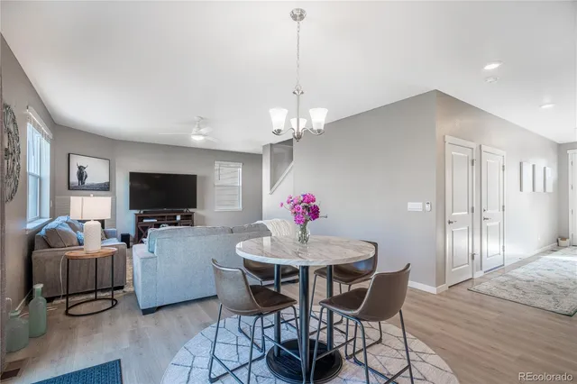 a dining room with furniture a chandelier and wooden floor