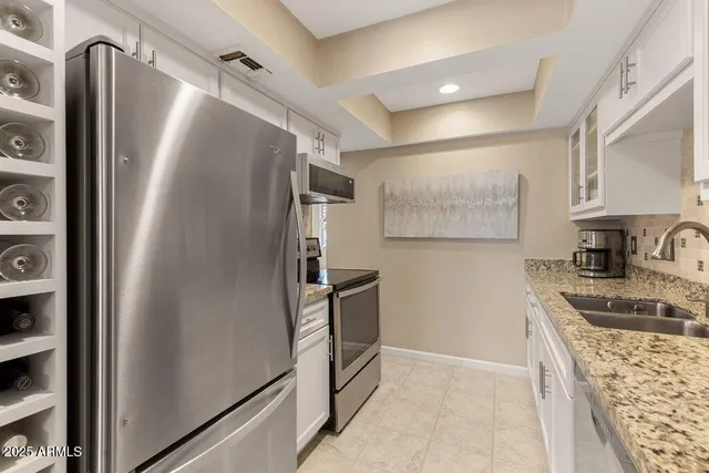 a kitchen with stainless steel appliances granite countertop a sink and cabinets
