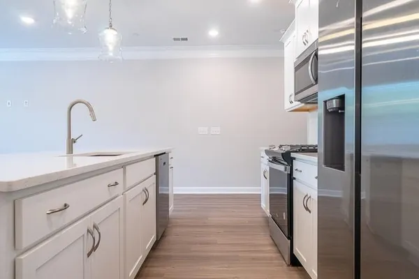 a kitchen with white cabinets and stainless steel appliances