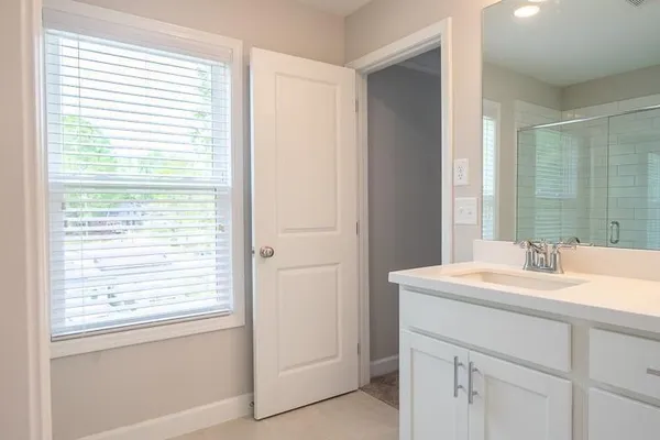 a bathroom with a granite countertop bathtub shower sink vanity and toilet