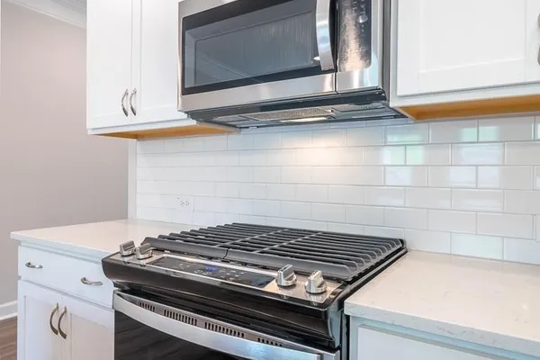a stove top oven sitting inside of a kitchen