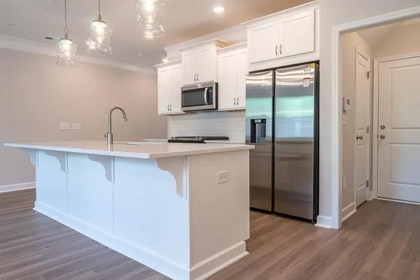 a kitchen with kitchen island a counter top space cabinets and stainless steel appliances