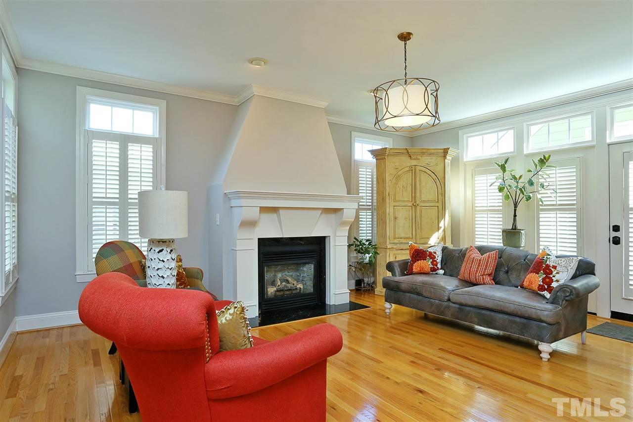 1164 Harp Street Raleigh, NC 27604 - Photo 13 of 25 a living room with furniture a chandelier and a fireplace