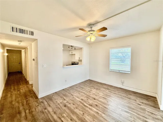 a view of an empty room with wooden floor