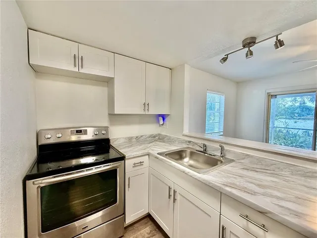 a kitchen with a stove and white cabinets