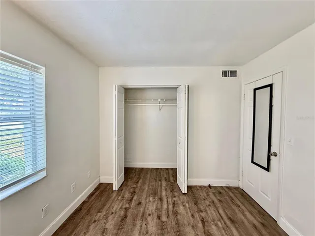 a view of a room with wooden floor and window